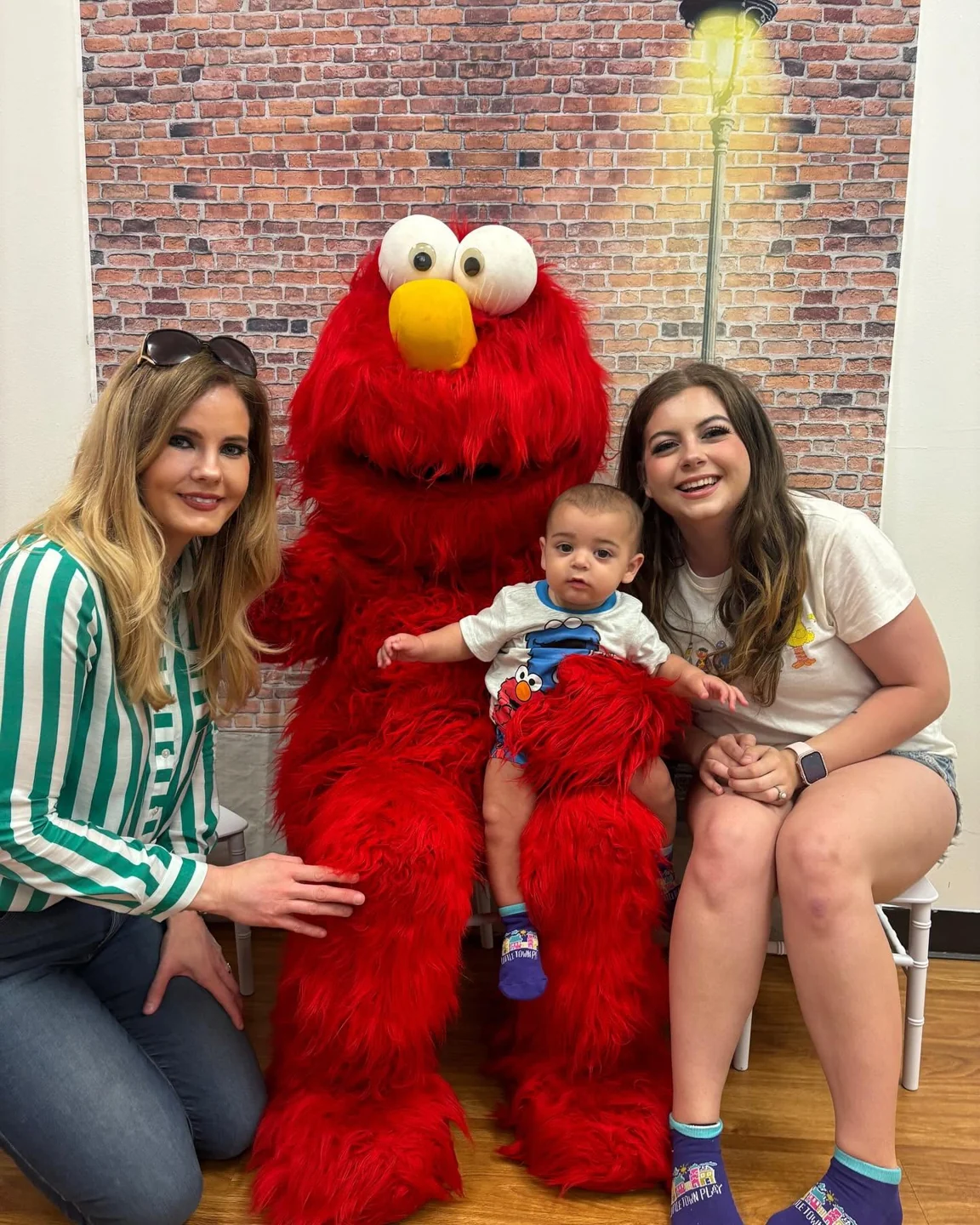A group posing with a red costumed character during an outing