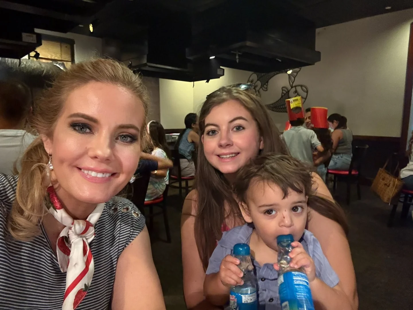 Two adults and a young child together at a restaurant